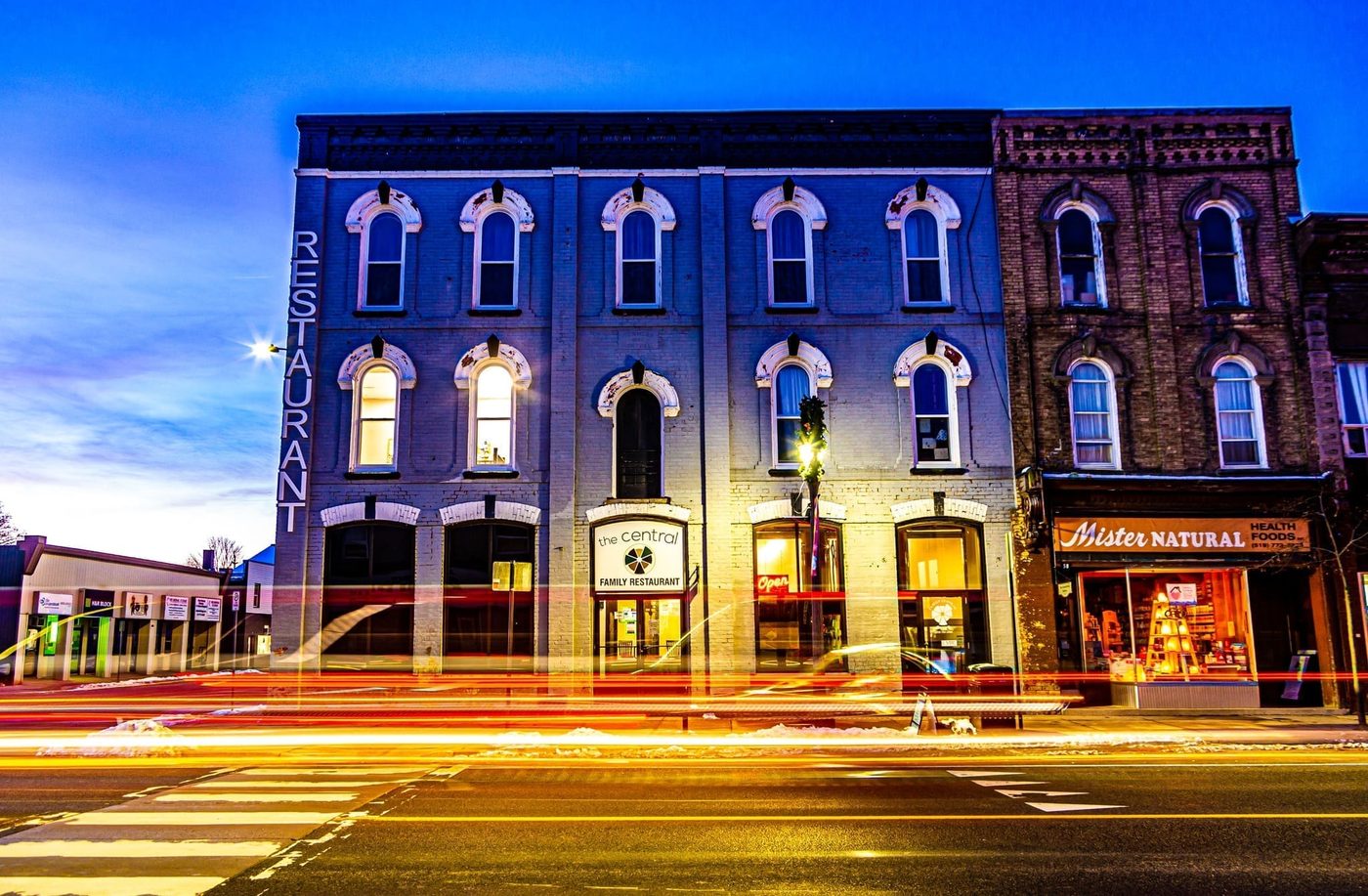 The Central Family Restaurant's brick storefront at dusk, with streaks of passing headlights on the street