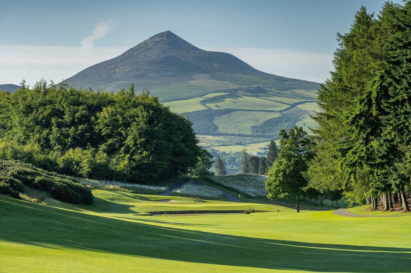 A fairway on the East Course at Powerscourt, with the Great Sugar Loaf mountain rising behind the trees